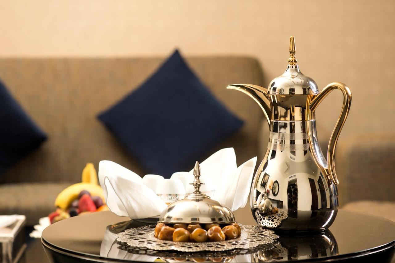 Al Ghufran Safwah Hotel Makkah Mekka Eksteriør billede The photo features a beautifully arranged setting. There is a shiny, ornate coffee pot made of metal, often associated with traditional Arabic coffee. Next to it is a decorative dish, also metallic, likely used for serving sweets or snacks. The dish 